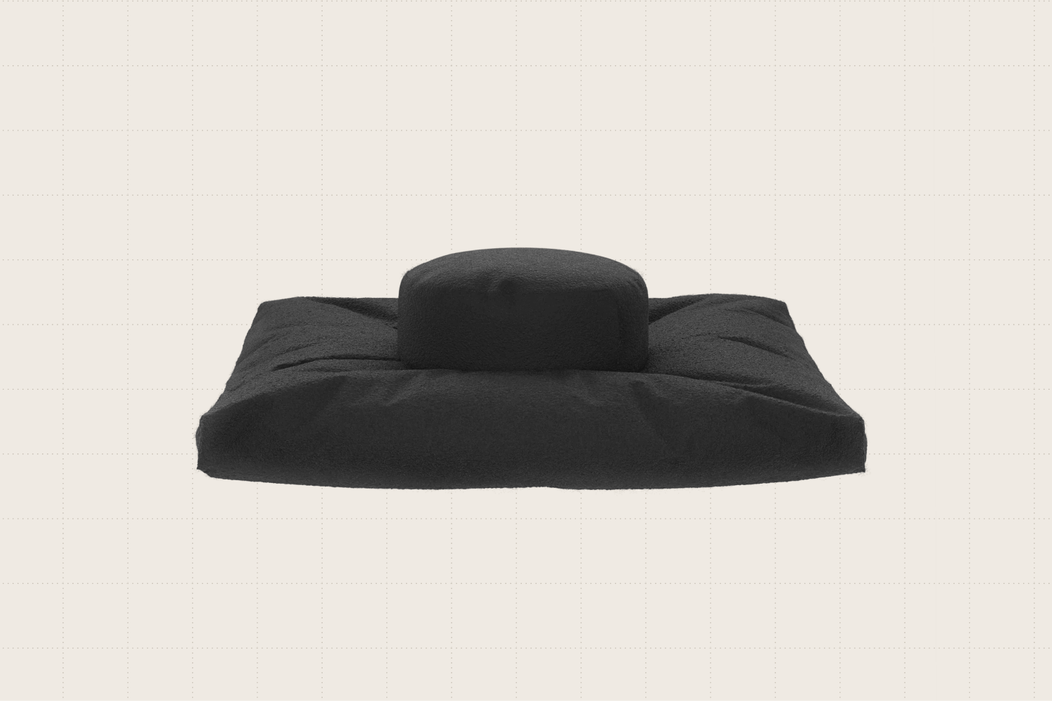 A bouclé meditation pillow shown in black. It's a flat, rectangular cushion with another raised, round cushion in the center.