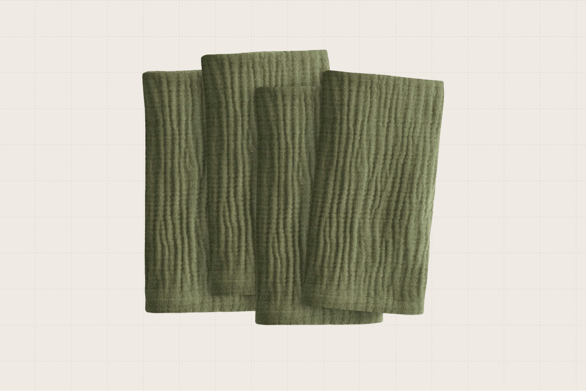 Four olive green Quince Organic Airy Gauze Napkins. They look soft and textured, and are each folded in half.