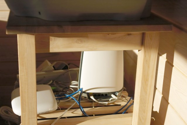 A photo of the wires and cables under a desk. They are all jumbled together and messy looking.