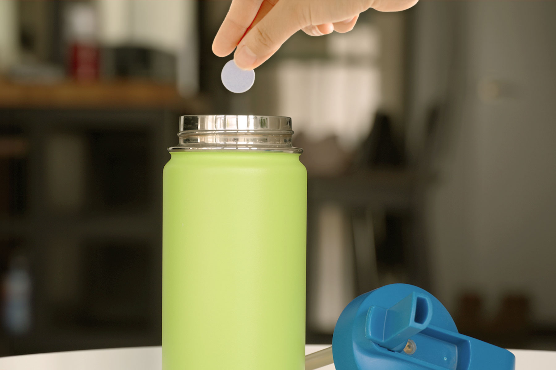 Putting denture tablet in reusable water bottle