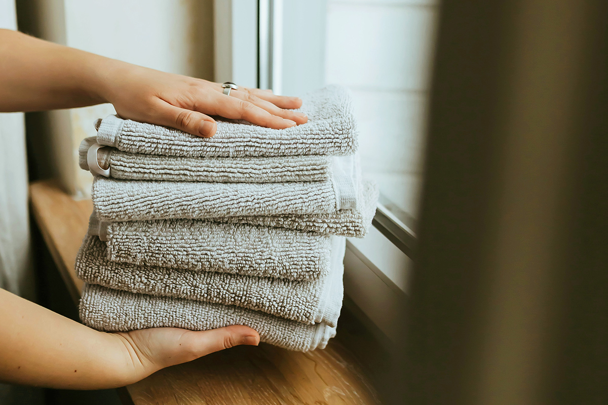 Person holding a stack of towels