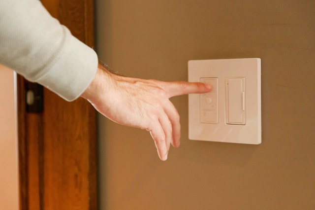 Anonymous person flipping a light switch on.