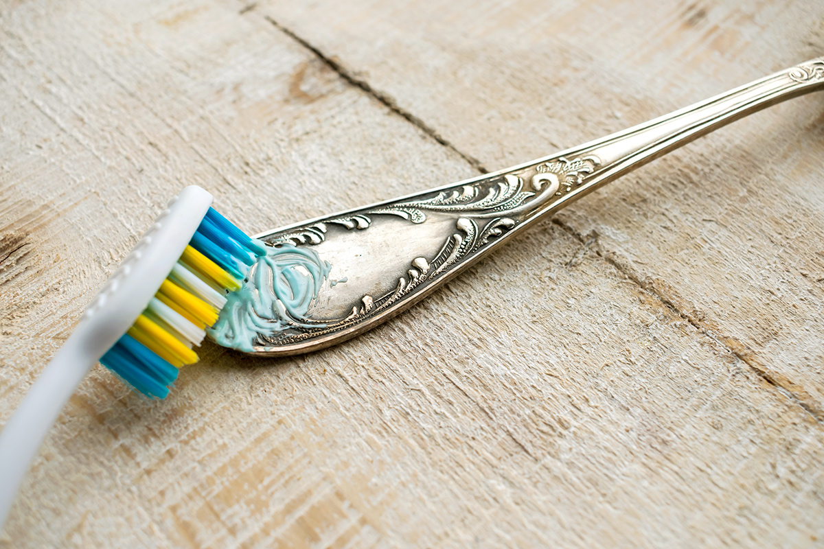 Cleaning the cutlery with a toothbrush and paste